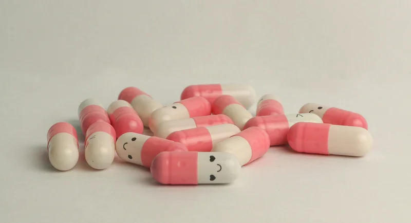 White and pink pills with smiley faces
