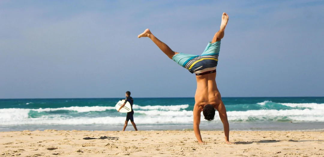 Man doing a handstand on the beach