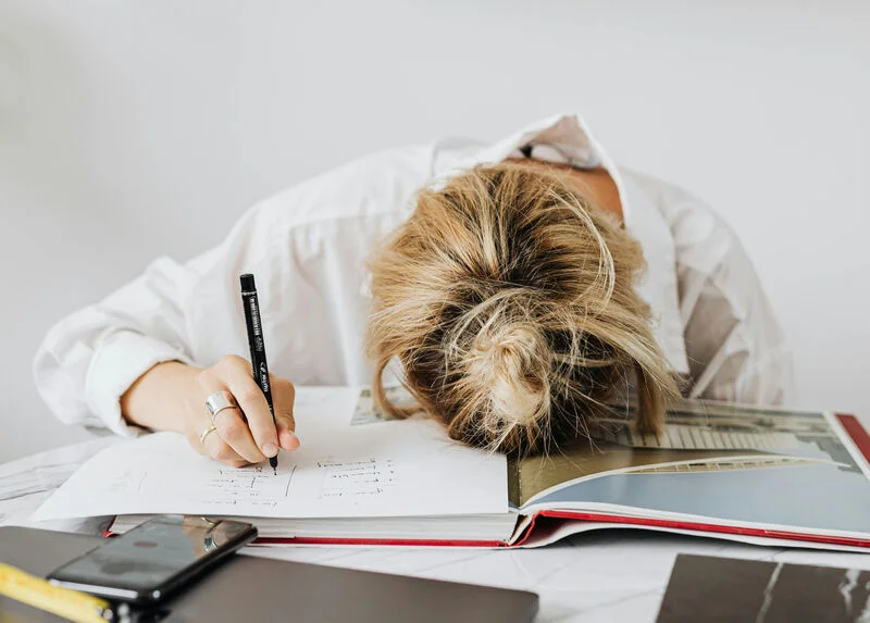 Stressed out woman with head on desk