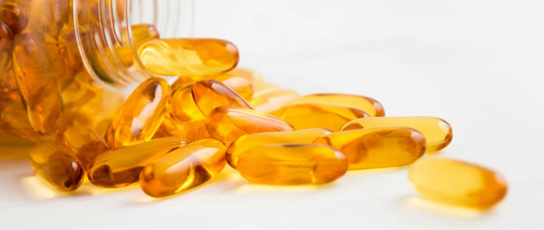 Yellow pills spilling from a glass bottle