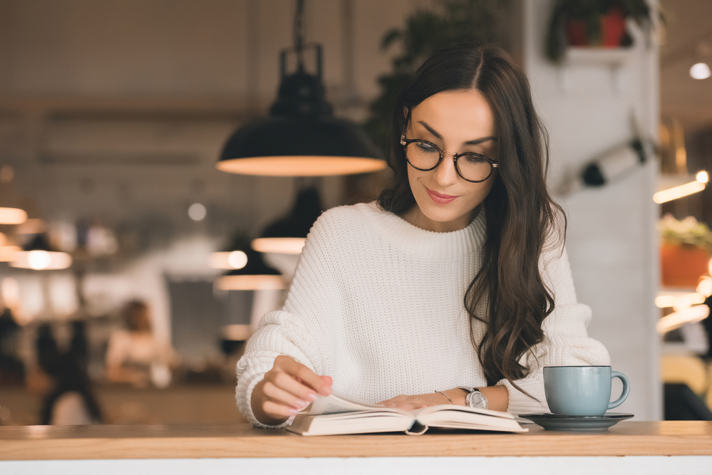 Woman reading in a book at a cafe